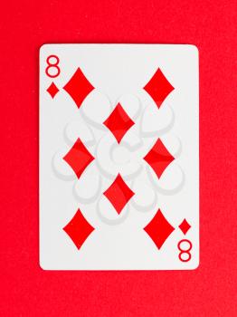 Old playing card (eight) isolated on a red background