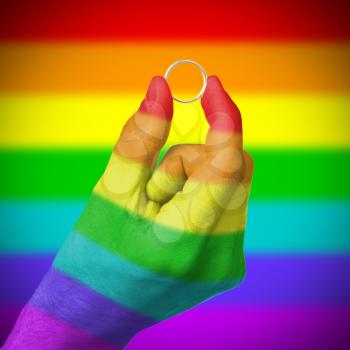 Man holding a silver ring, rainbow flag pattern