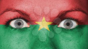 Close up of eyes. Painted face with flag of Burkina Faso