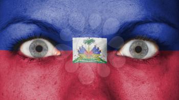 Close up of eyes. Painted face with flag of Haiti
