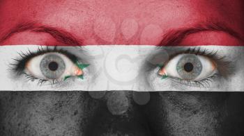 Close up of eyes. Painted face with flag of Syria