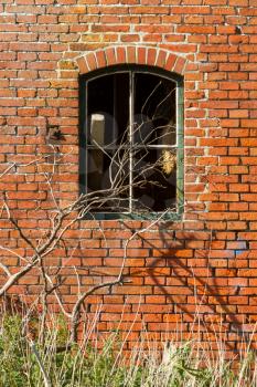 Broken window in an old brick wall