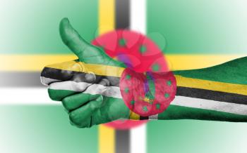 Old woman giving the thumbs up sign, isolated, flag of Dominica