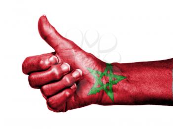 Old woman with arthritis giving the thumbs up sign, wrapped in flag pattern, Morocco