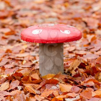 Large metal mushroom standing in a field of leaves
