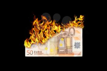 Burning money, euro bill on fire, isolated on black