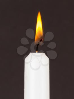 White candle isolated against a black background