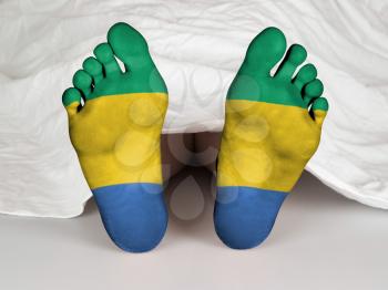 Feet with flag, sleeping or death concept, flag of Gabon