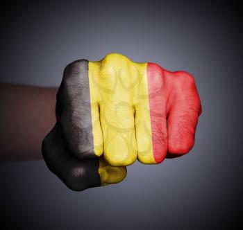 Front view of punching fist on gray background, flag of Belgium