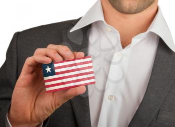 Businessman is holding a business card, flag of Liberia