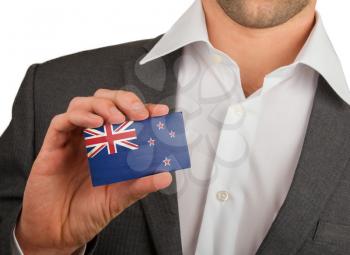 Businessman is holding a business card, flag of New Zealand