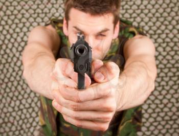 Soldier in camouflage vest is holding a gun, isolated