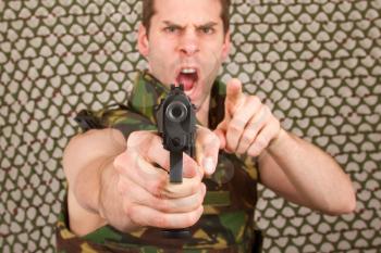 Soldier in camouflage vest is holding a gun, isolated