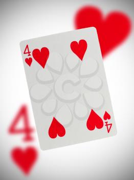 Playing card with a blurry background, four of hearts