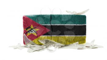 Brick with broken glass, violence concept, flag of Mozambique