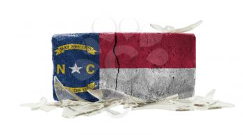Brick with broken glass, violence concept, flag of North Carolina