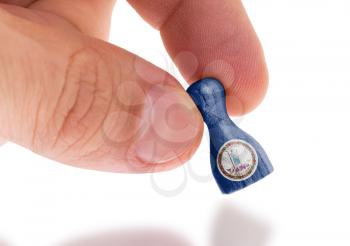 Hand holding wooden pawn with a flag painting, selective focus, Virginia