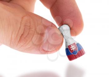Hand holding wooden pawn with a flag painting, selective focus, Slovakia