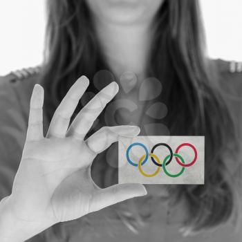 Woman showing a business card, Olympic Rings