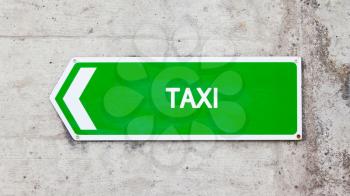 Green sign on a concrete wall - Taxi