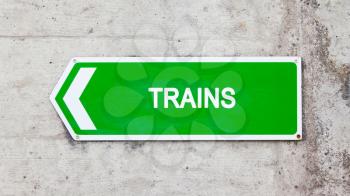 Green sign on a concrete wall - Trains