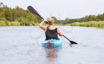 Woman on a small river in rural landscape, the Netherlands