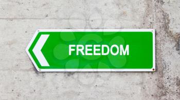 Green sign on a concrete wall - Freedom