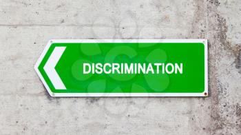 Green sign on a concrete wall - Discrimination