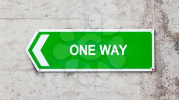 Green sign on a concrete wall - One way