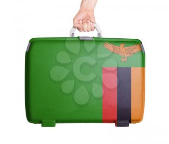 Used plastic suitcase with stains and scratches, printed with flag, Zambia