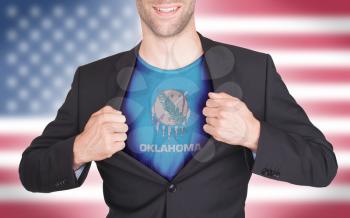 Businessman opening suit to reveal shirt with state flag (USA), Oklahoma