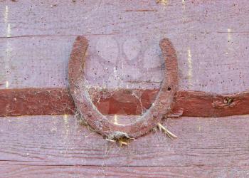 Old lucky horseshoe on brown wooden wall
