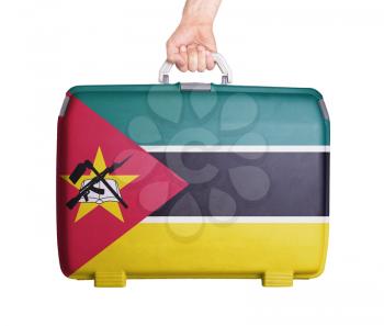 Used plastic suitcase with stains and scratches, printed with flag, Mozambique