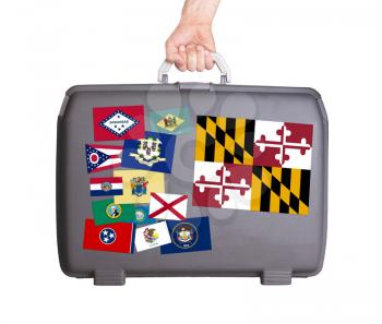 Used plastic suitcase with stains and scratches, stickers of US States, Maryland