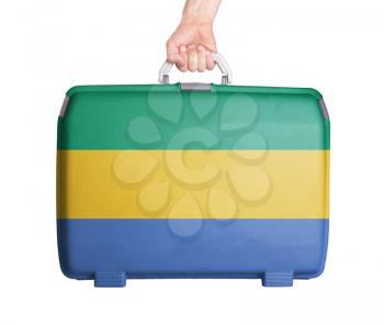 Used plastic suitcase with stains and scratches, printed with flag, Gabon