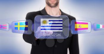 Hand pushing on a touch screen interface, choosing language or country, Uruguay