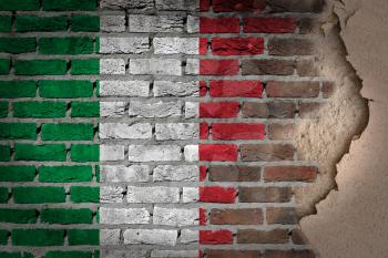 Dark brick wall texture with plaster - flag painted on wall - Italy