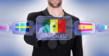 Hand pushing on a touch screen interface, choosing language or country, Senegal