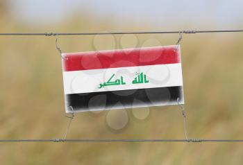 Border fence - Old plastic sign with a flag - Iraq