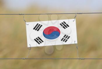 Border fence - Old plastic sign with a flag - South Korea