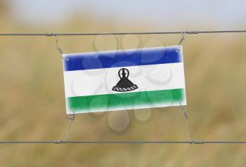 Border fence - Old plastic sign with a flag - Lesotho