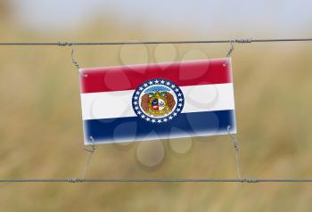 Border fence - Old plastic sign with a flag - Missouri