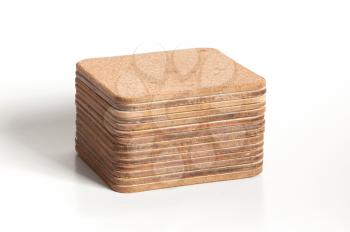 Pile of cork textured coasters isolated on white