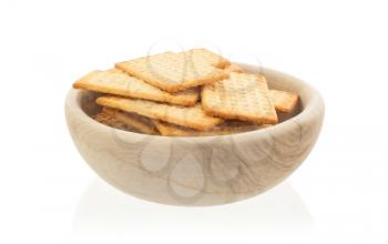 Simple crackers in a wooden bowl, isolated on a white background