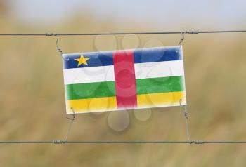 Border fence - Old plastic sign with a flag - Central African Republic