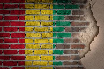 Dark brick wall texture with plaster - flag painted on wall - Guinea