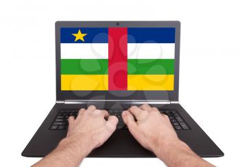 Hands working on laptop showing on the screen the flag of Central African Republic
