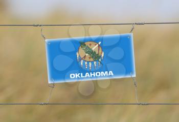 Border fence - Old plastic sign with a flag - Oklahoma