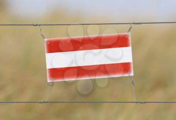 Border fence - Old plastic sign with a flag - Austria