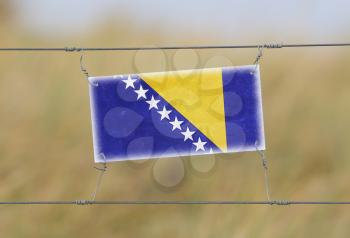 Border fence - Old plastic sign with a flag - Bosnia and Herzegovina
